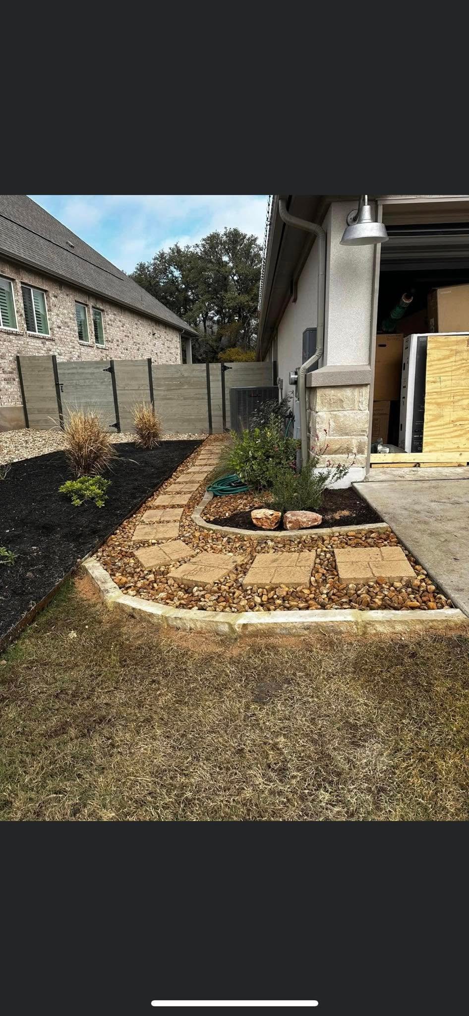 Side yard after installing a paver walkway with river rock border