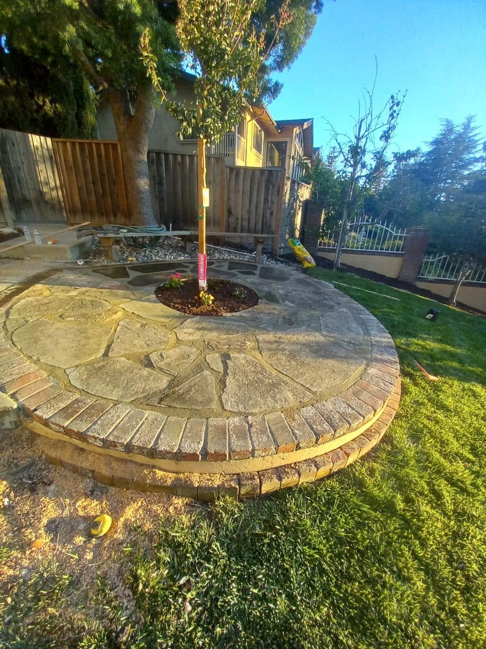 Circular stone and brick patio built around a newly planted tree